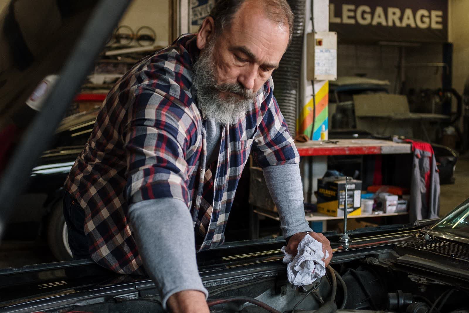 A mechanic leans into an engine bay in the shop.
