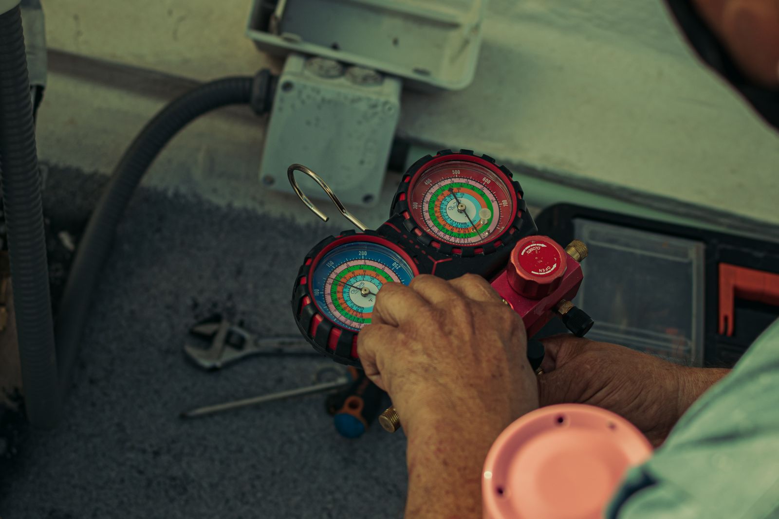 A technician checks the pressure gauges on an air conditioner.